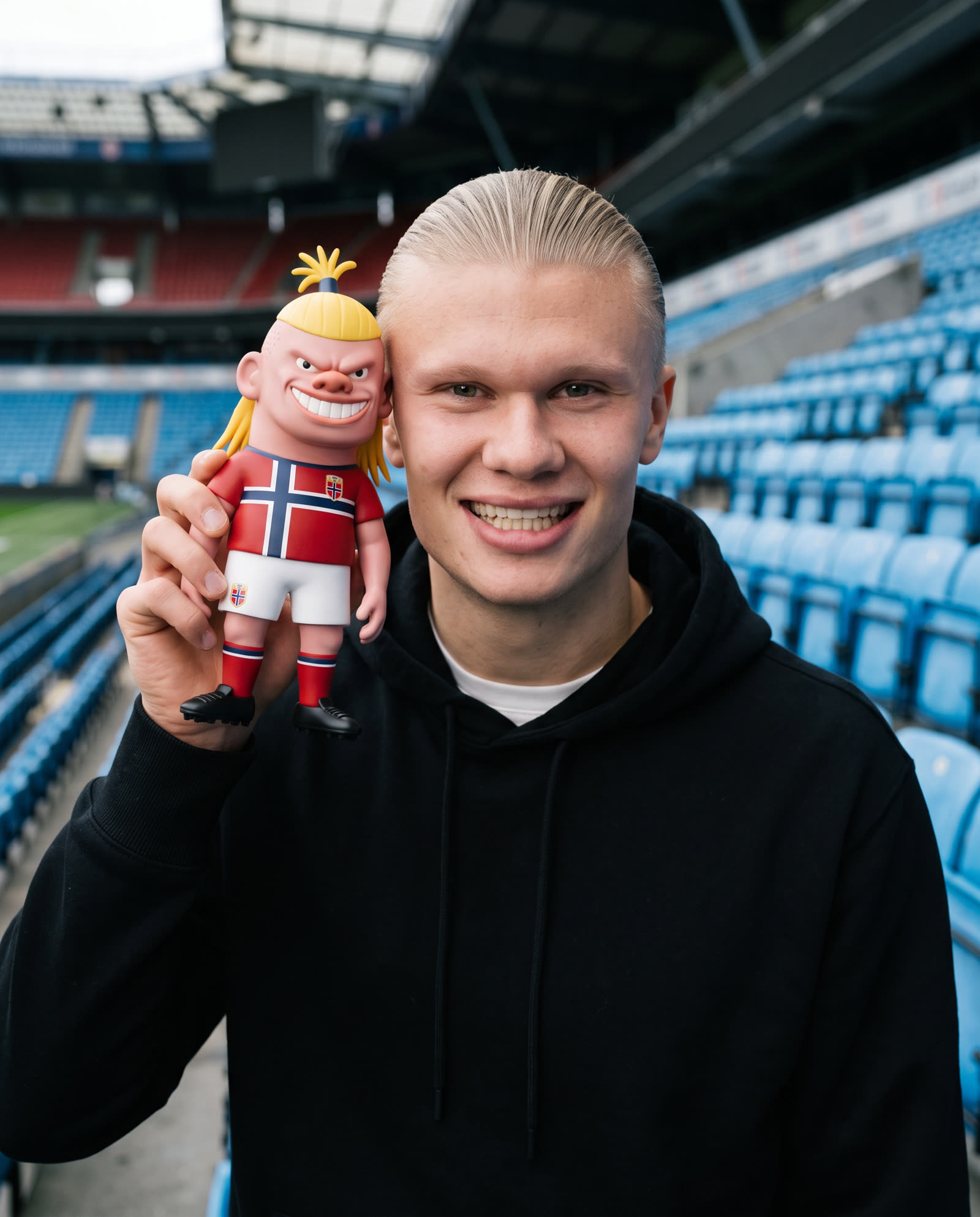 Erling Haaland sosteniendo la figura en el estadio